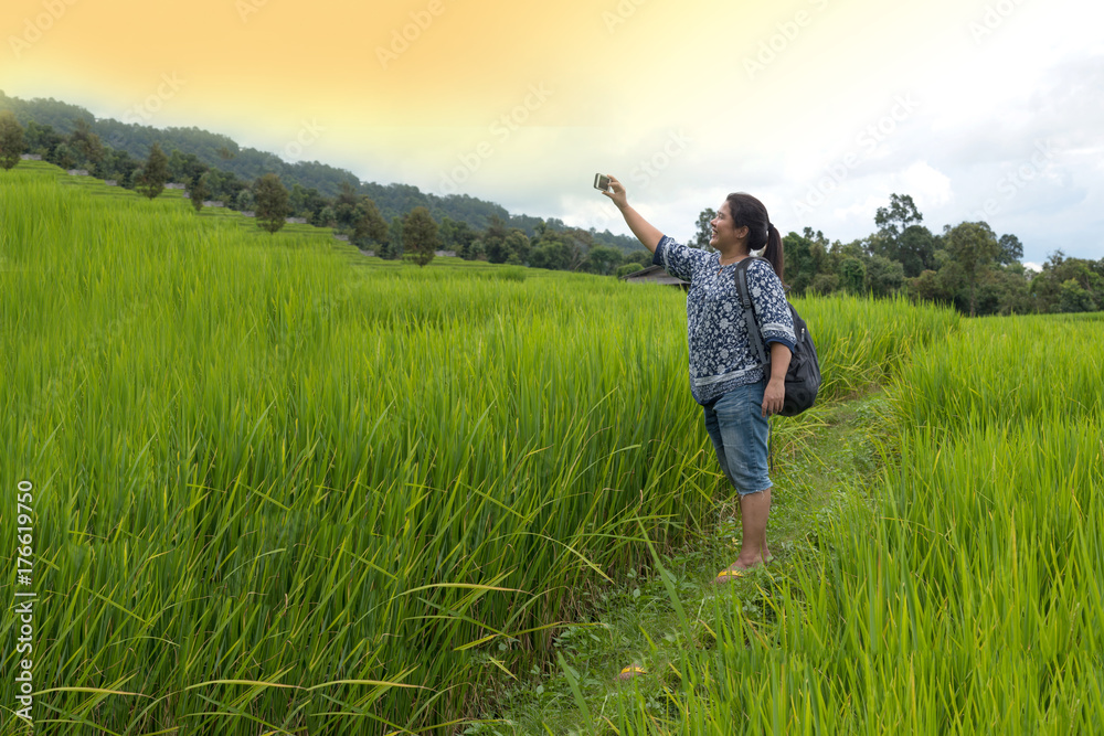 A woman, tourism standing and take photo beautiful view green rice fields on terraces in Thailand at Ban Pa Pong Pieng in Mae chaem, Chaing Mai.
