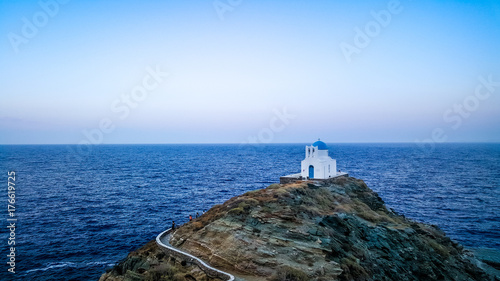 greek orthodox chapel on a cliff on a greek island in the middle of the sea photo