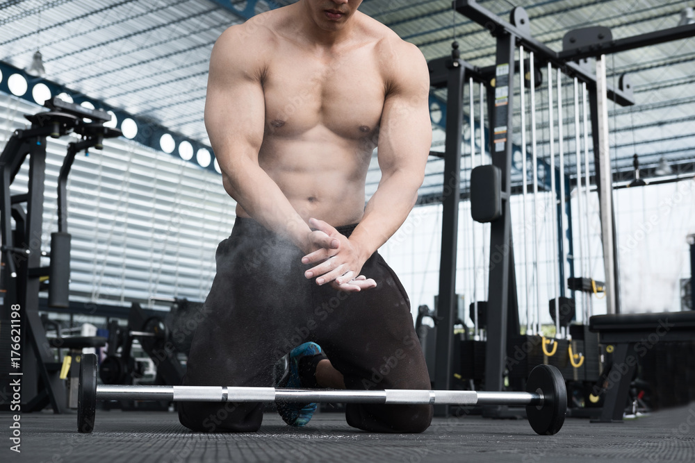 muscular man clap hand in fitness center. male athlete pump up muscle in gym. weightlifter work out with barbell in health club. training, sport, lifestyle concept muscular man clap hand in fitness center. male athlete pump up muscle in gym. weightlifter work out with barbell in health club. training, sport, lifestyle concept