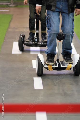 Competition on self balancing hoverboard scooters. Men are finishing, modern sports