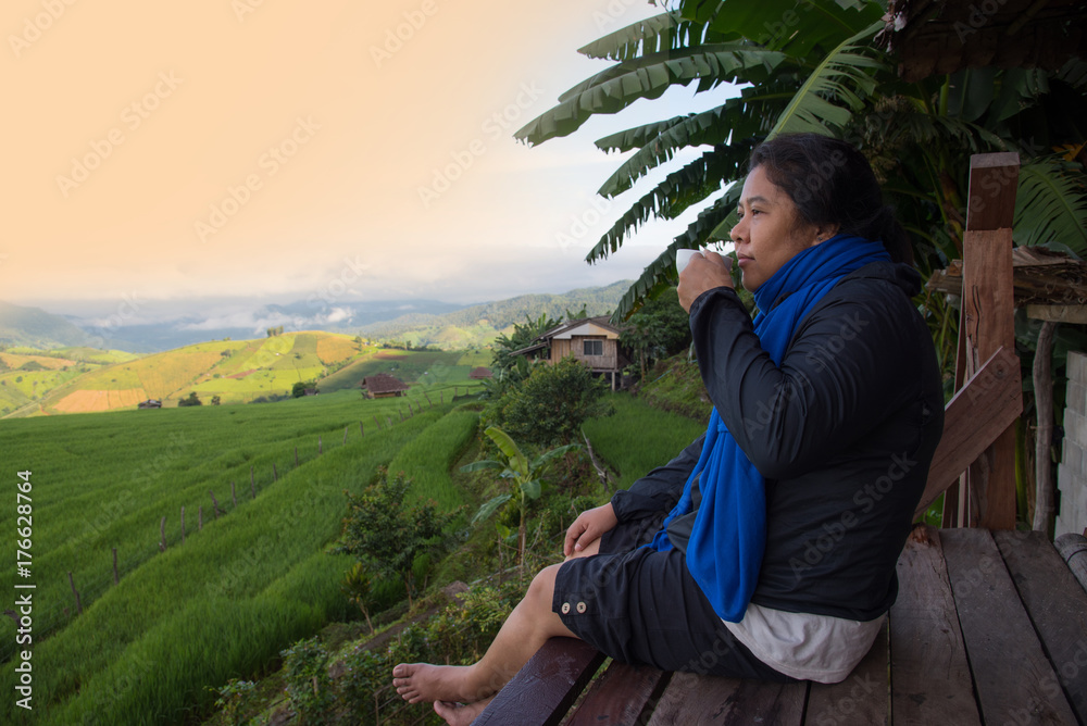 Woman tourism sitting on wood balcony smelling and drinking hot coffee in morning time and enjoy to see view of green rice field at Napongpeng,Chiangmai-Thailand
Woman tourism sitting on wood balcony smelling and drinking hot coffee in morning time and enjoy to see view of green rice field at Napongpeng,Chiangmai-Thailand