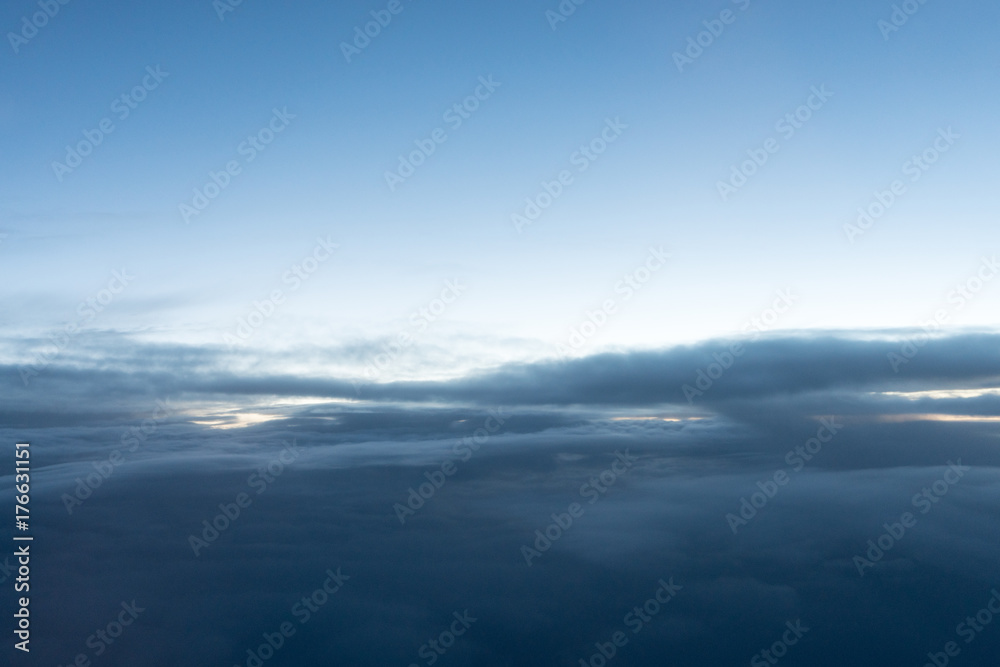 Sunrise above clouds seen through airplane window