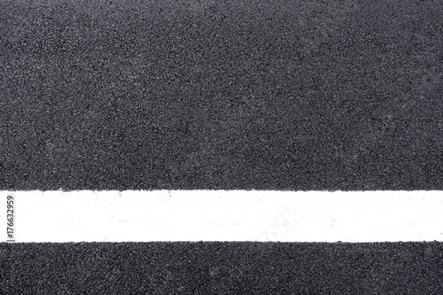 white lines on the asphalt road surface background texture © Phawat