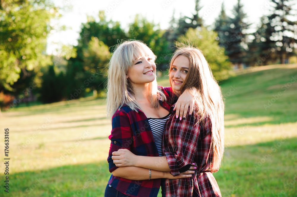 Fototapeta premium Two girls friends laughing and hugging. Hug and smile outdoor