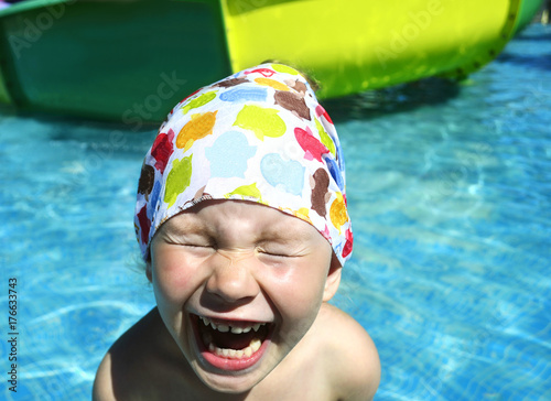 The little girl laughs with her eyes closed.