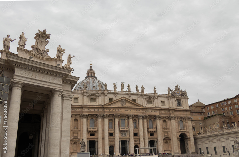 View of the old Roman and Vatican city's historic buildings and decorated with a dome of a basilica on a gray cloudy day