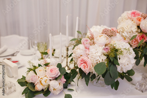 Table decor with white flowers and candles for a wedding party © kotelnyk