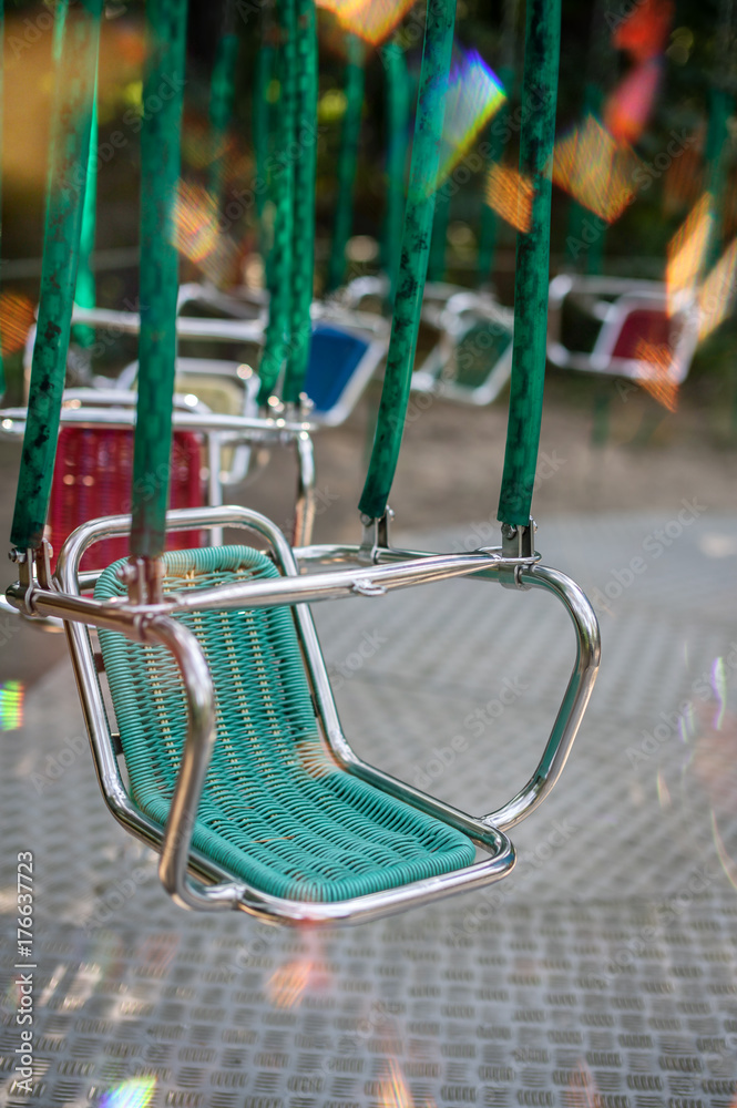 Green empty carousel seat at summer funfair Green empty carousel seat at summer funfair