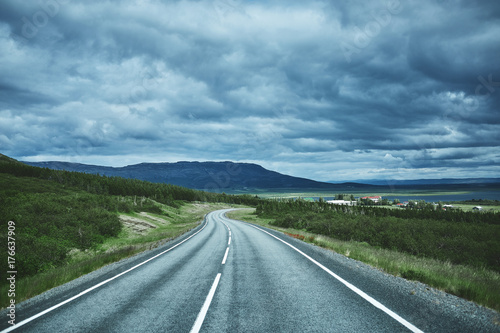 Travel to Iceland. plot of asphalt road in a bright sunny mountain landscape. focus on the road
