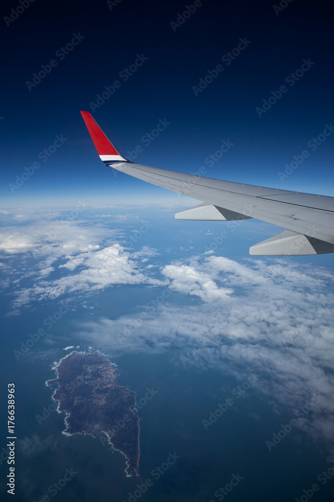 Blick aus dem Flugzeug auf den Ozean mit Cumulus Wolken und Insel Blick aus dem Flugzeug auf den Ozean mit Cumulus Wolken und Insel