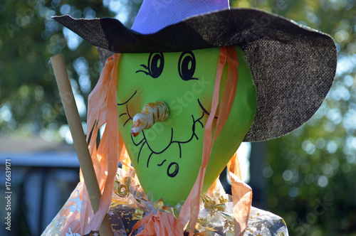 Closeup photo of a funny, smiley witch in a Halloween decoration in the yard photo