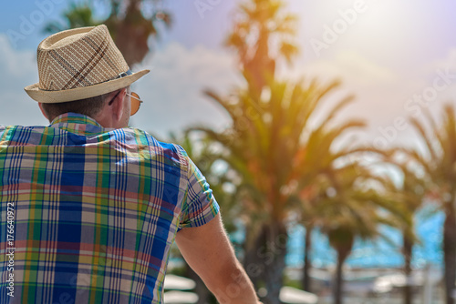 Man in sunhat watching at beautiful sea view. Back view.
