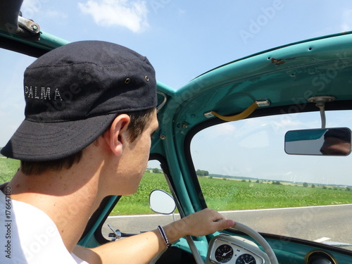 Young man driving heinkel cabin (vintage car) in turquoise 3 photo