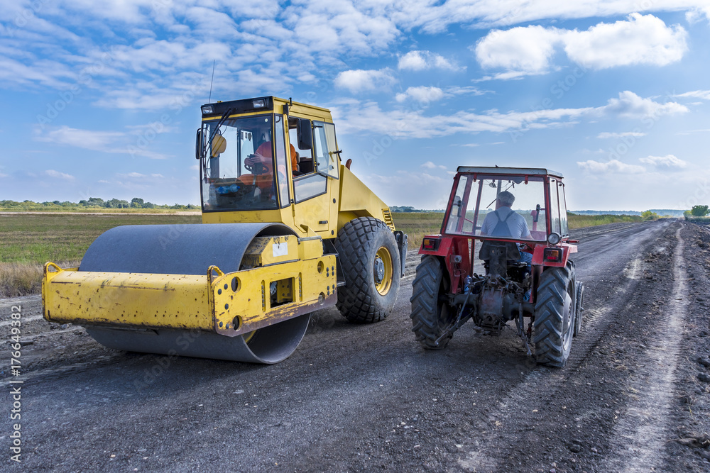 Roller and tractor on a gravel road