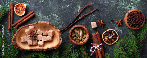 Traditional Christmas spices on green background.