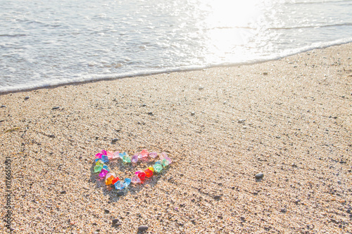 Brightly colored heart of glass pebbles on the sea shore
