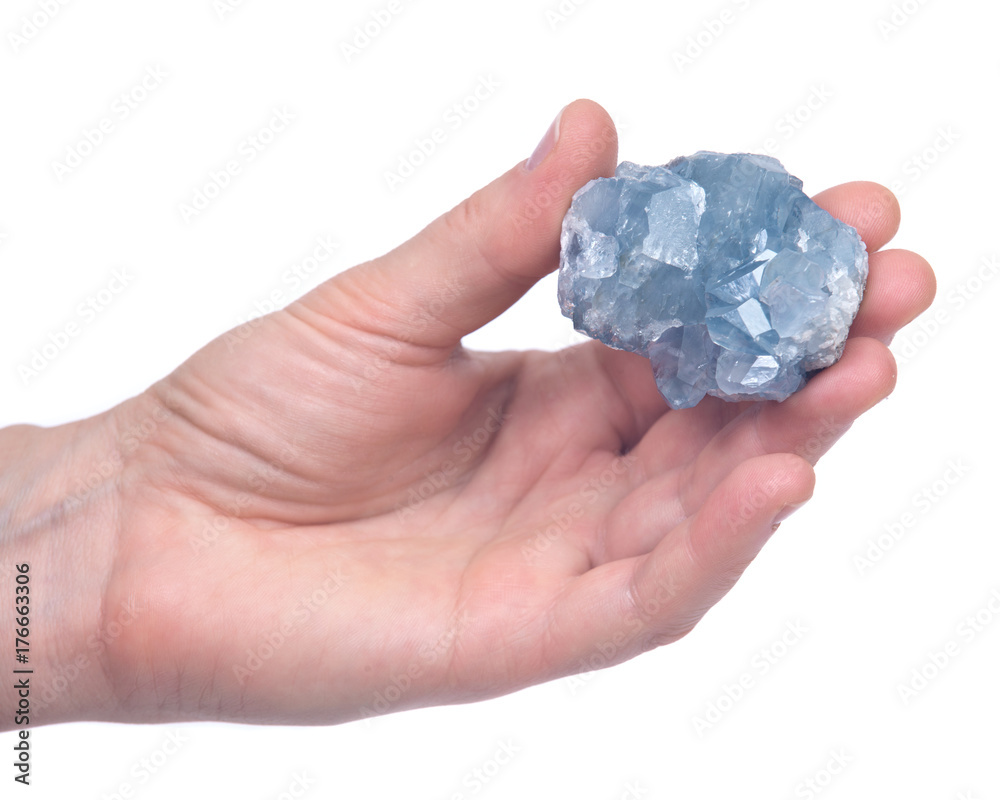 Woman's hand holding blue celestite cluster isolated on white background Woman's hand holding blue celestite cluster isolated on white background