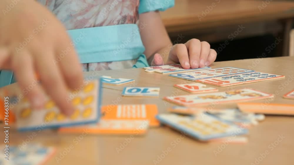 Close-up of hands of unidentified little girl playing developing game ...