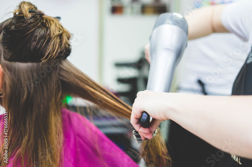 Tableau sur toile Woman hairdresser making hairstyle in barbershop