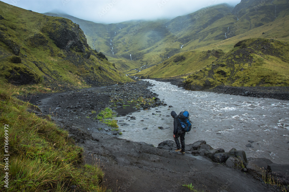 Hiking with backpack at Iceland green mountains