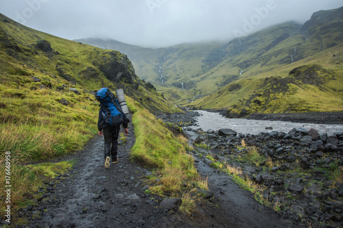 Hiking with backpack at Iceland green mountains