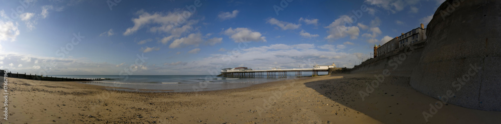 Panoram of Cromer beach with groyne and pier in the background