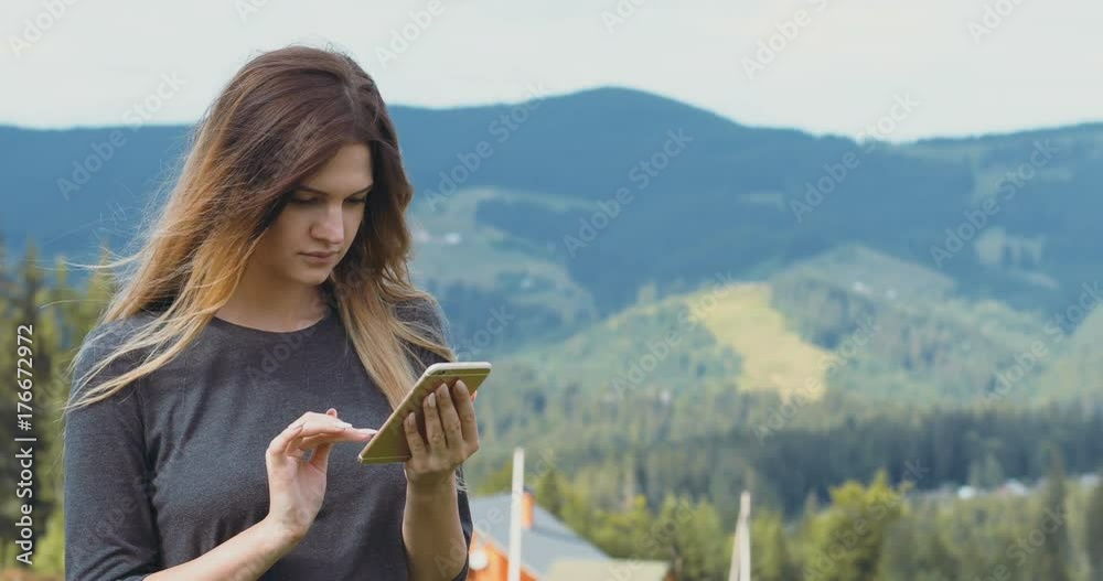 Traveling pretty woman standing mobile smart phone gadget high mountains touristic sunshine communication pointing finger touch screen social network map application silence magic place exciting
