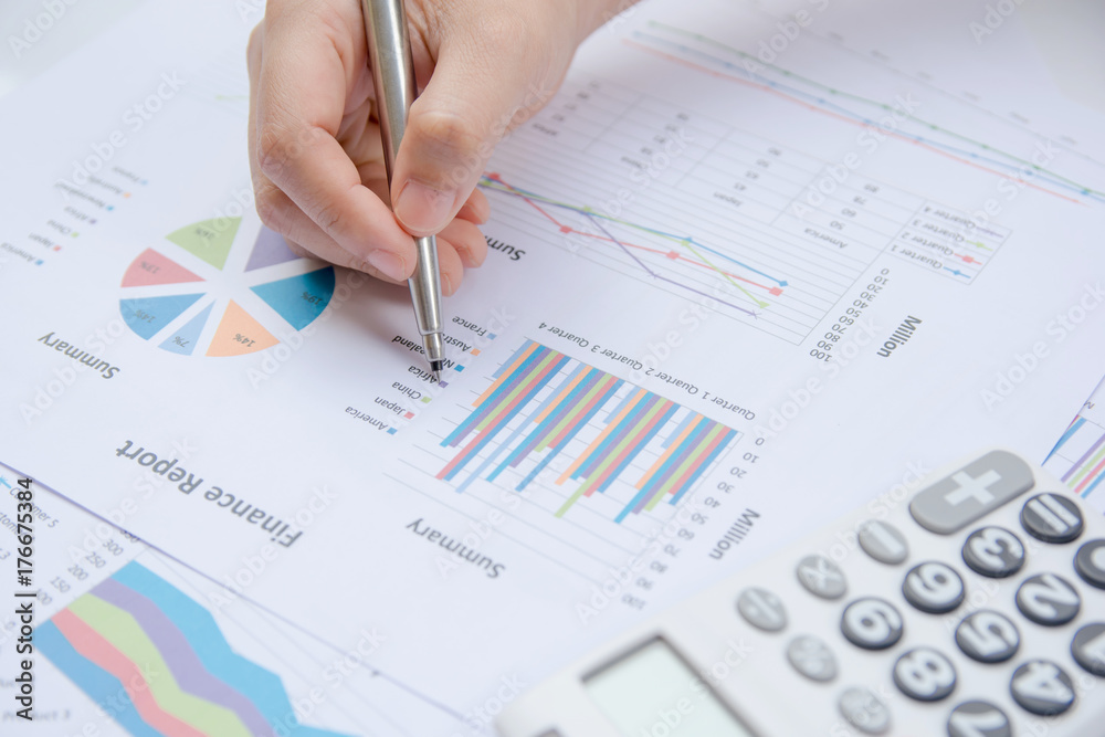 Woman hand holding pen pointing on summary report chart and calculate finance. Woman hand holding pen pointing on summary report chart and calculate finance.