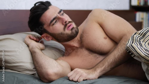 Young Handsome Shirtless Sleepy Man, Lying in Bed Yawning as He's Waking Up