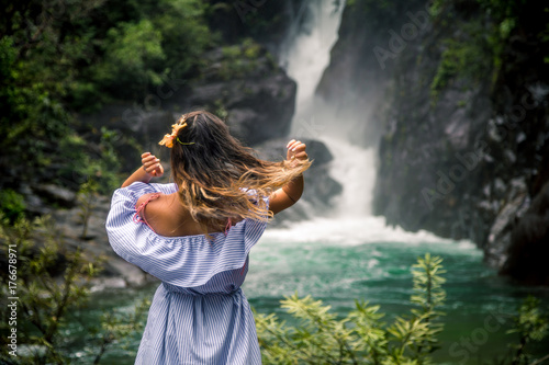 Fototapeta Naklejka Na Ścianę i Meble -  the girl looks at the waterfall back