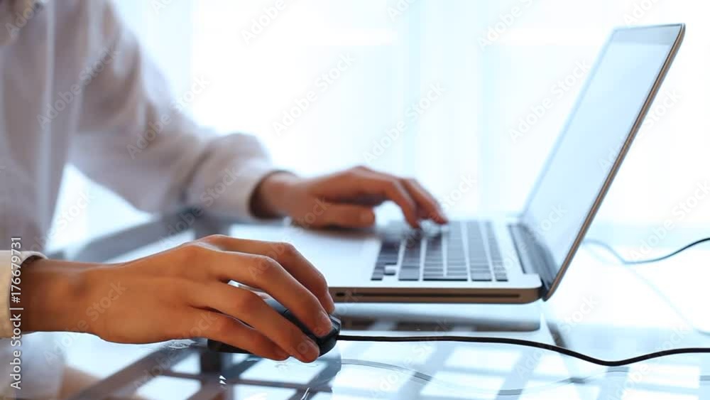 Closeup of woman hand typing on laptop keyboard with mouse Closeup of woman hand typing on laptop keyboard with mouse