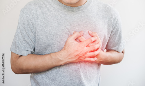 a man touching his heart, with red highlight of heart attack, and others heart disease concept, on white background photo