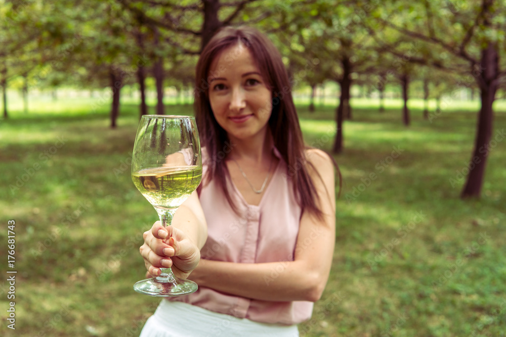 Fototapeta premium Young woman with white wine in the park