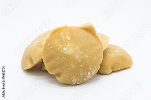 Brown raw palm sugar on white background, isolated