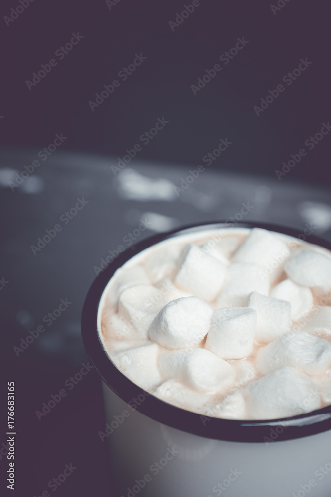 Cup of hot chocolate with marshmallows on the rustic wooden background. Shallow depth of field. Toned image. Cup of hot chocolate with marshmallows on the rustic wooden background. Shallow depth of field. Toned image.