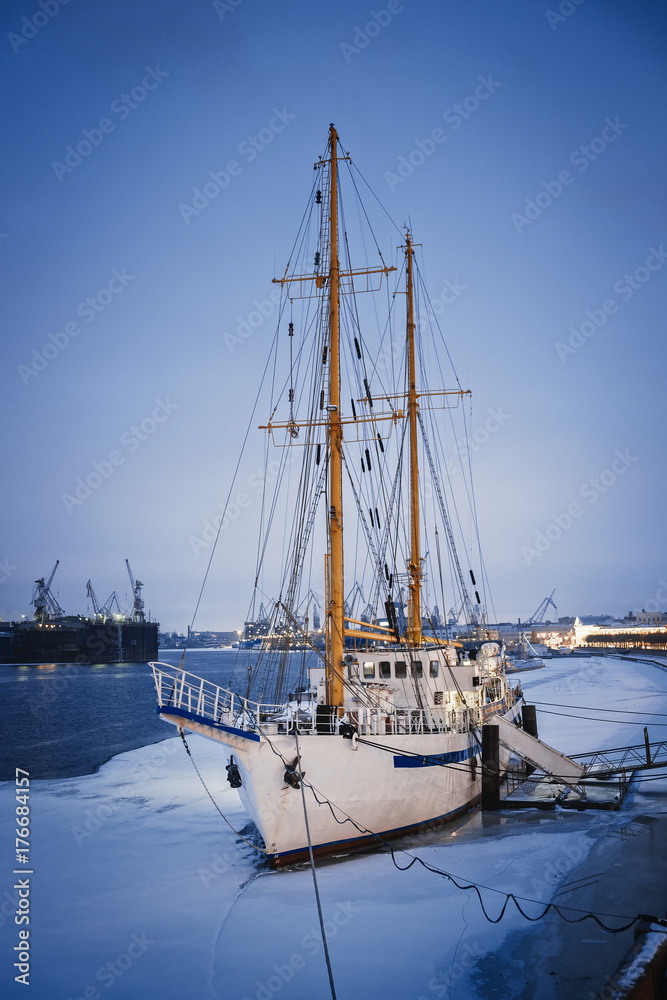 Sailing ship on the dock/Masted ship on the quay on the Neva river in winter, St. Petersburg, Russia