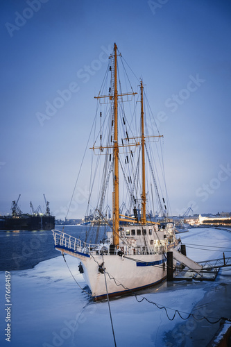 Sailing ship on the dock/Masted ship on the quay on the Neva river in winter, St. Petersburg, Russia