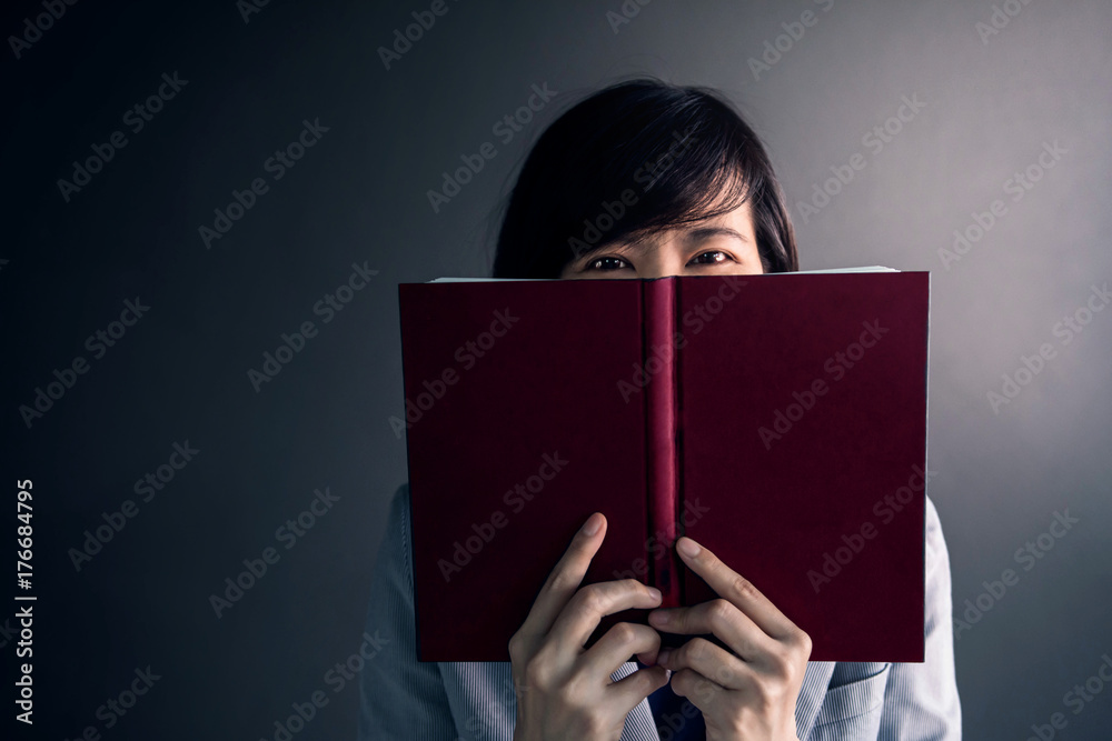 Reading Book Concept, Woman Standing at Dark wall with Smiley Happy Face Reading Book Concept, Woman Standing at Dark wall with Smiley Happy Face