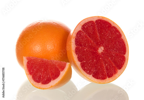 Grapefruit and juicy slice isolated on white