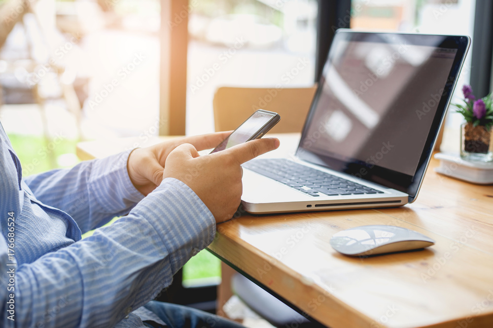 Business man at working with financial reports and using mobile smartphone in the office Business man at working with financial reports and using mobile smartphone in the office