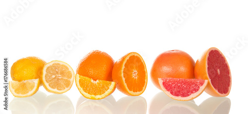 Beautifully laid whole citrus fruits and their slices isolated on white background