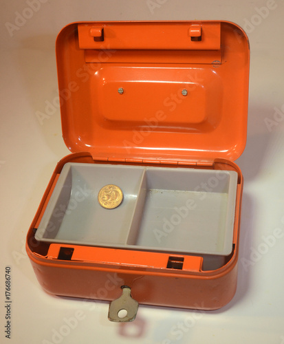 The money box is empty: orange strong box with ust one little coin.