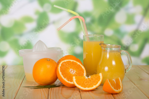 Oranges and jug of juice on wooden table