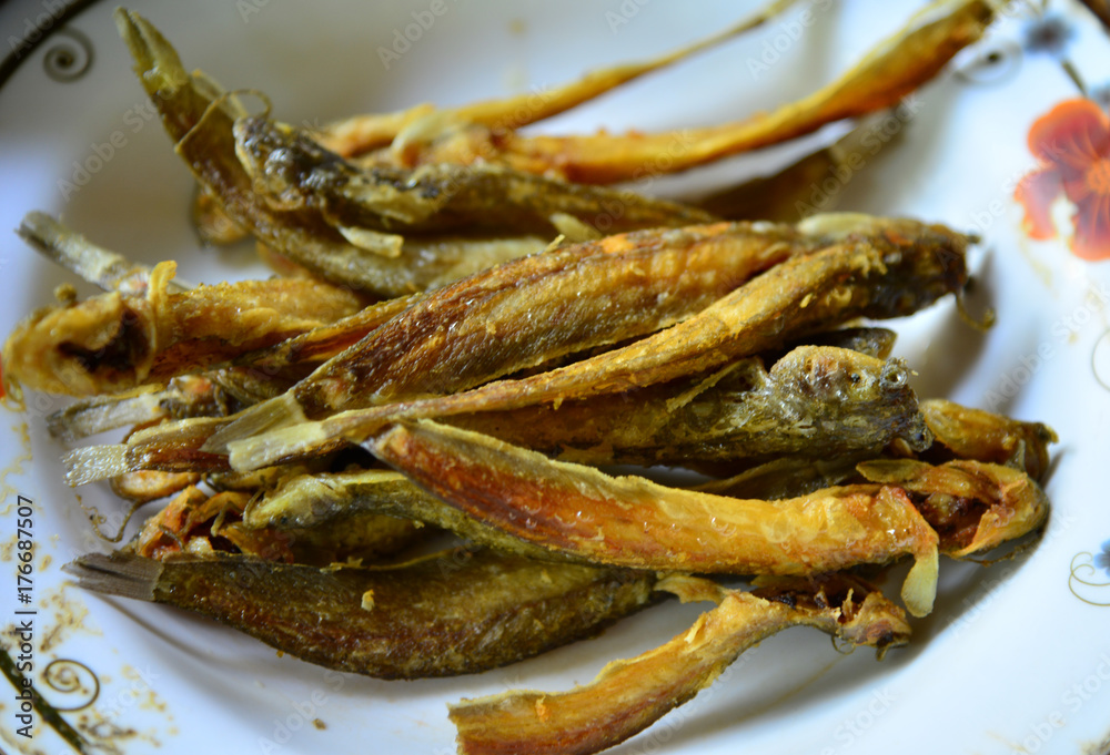 Fresh fried european anchovy on a white plate Fresh fried european anchovy on a white plate