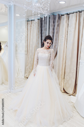 Bride in a beautiful wedding dress, sitting next to the sofa is the boudoir of the table