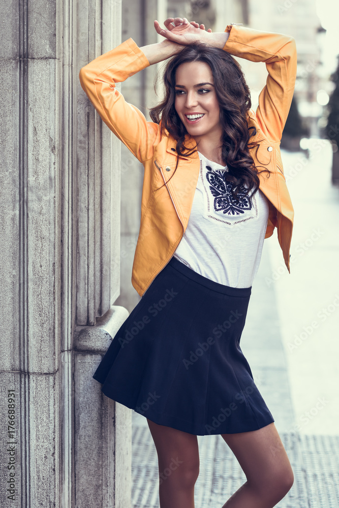 Obraz premium Young brunette woman smiling in urban background.