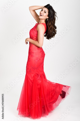 Young woman wearing long red dress on white background.