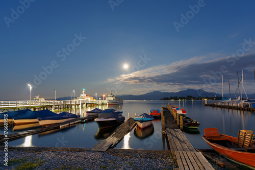 Ferries at Lake Chiemsee at harbour Gstadt at night with full moon, long time exposure