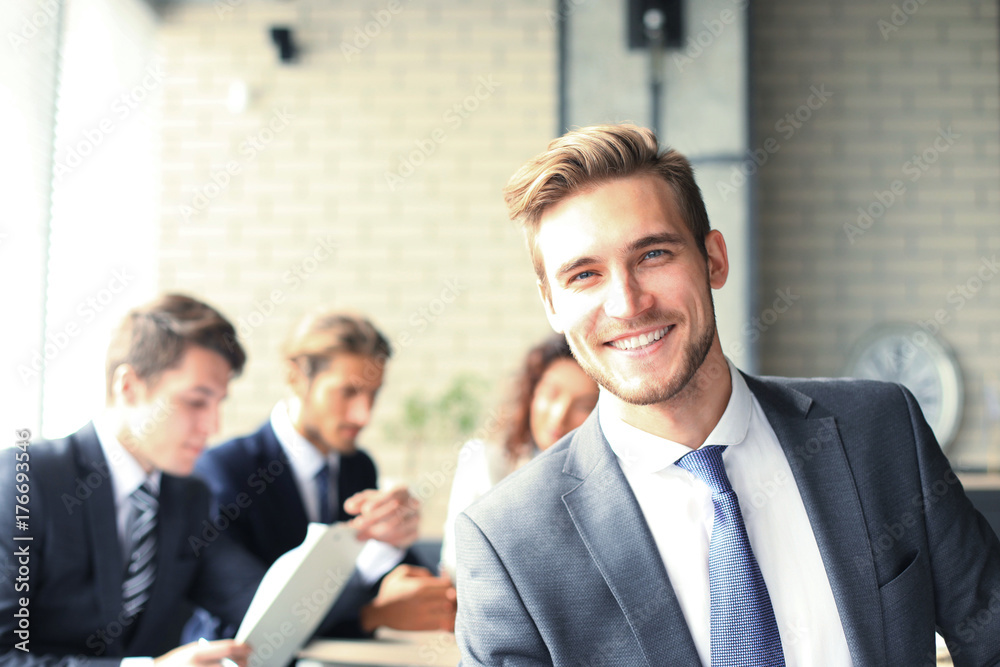 Businessman with colleagues in the background in office. Businessman with colleagues in the background in office.