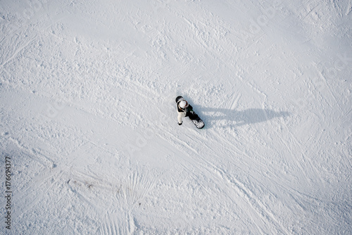 Top view of an active snowboarder in winter mountains.